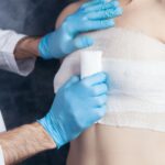 Ärztin versorgt eine Wunde mit einem Verband