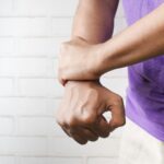 Person hält sich das schmerzende Handgelenk