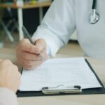 Arzt notiert Befunde im Patientengespräch
