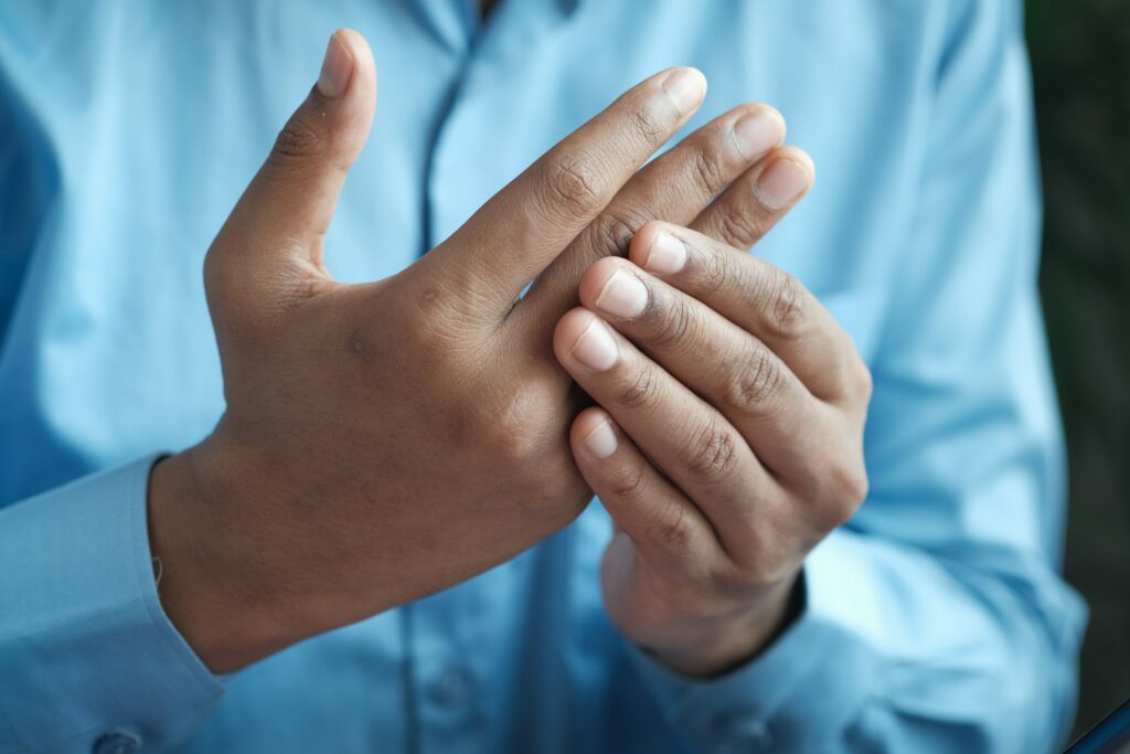 Person massiert ihren schmerzenden Finger
