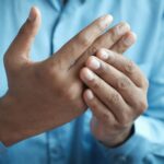 Person massiert ihren schmerzenden Finger