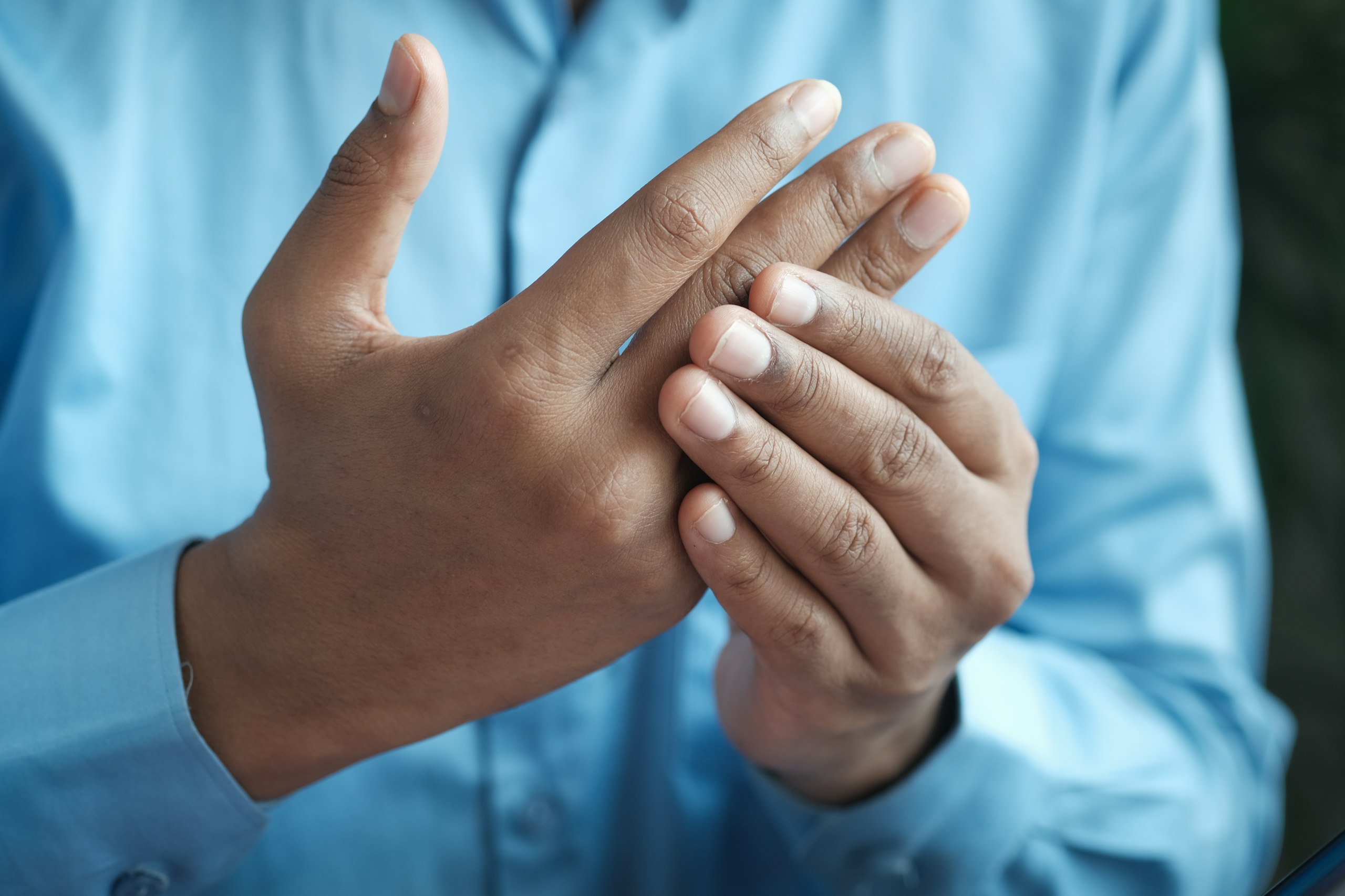 Person massiert ihren schmerzenden Finger