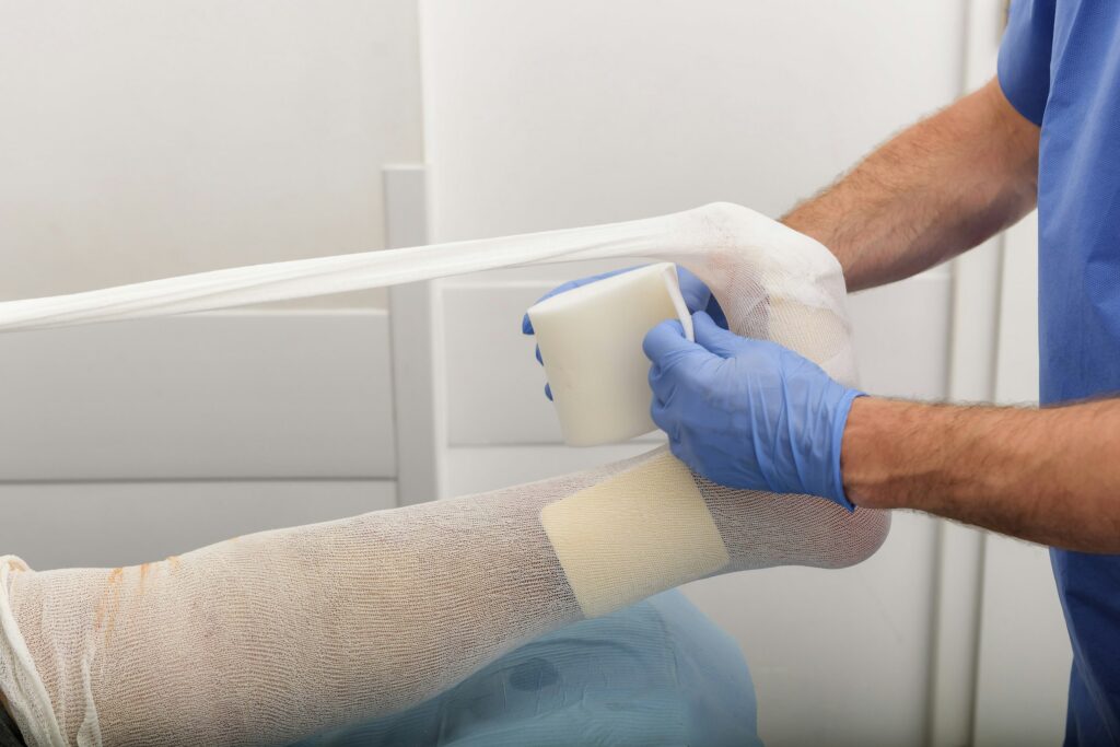 Arzt legt einem Patienten einen Verband an