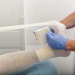 Arzt legt einem Patienten einen Verband an